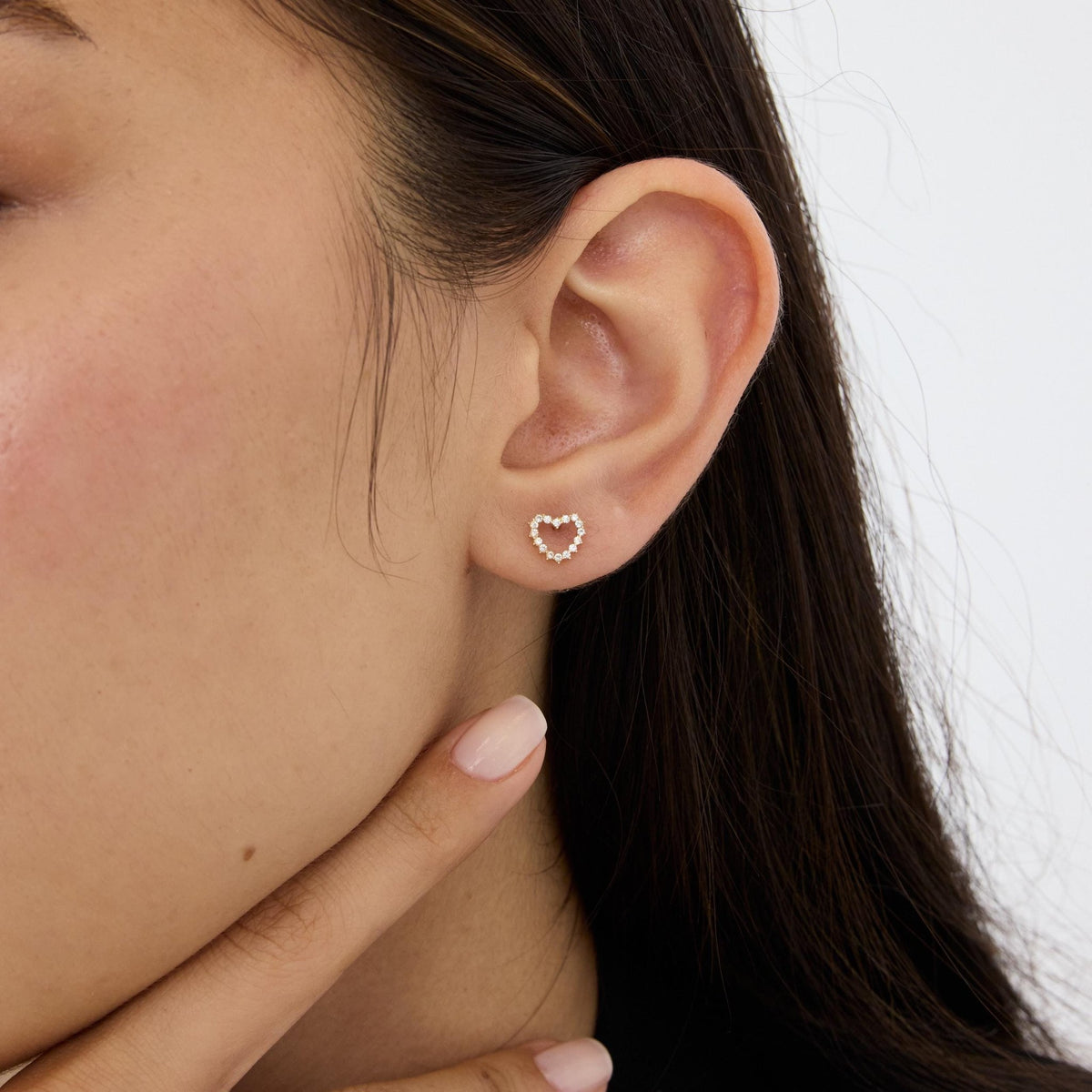 14K gold open heart stud earring with round cubic zirconia worn in the ear, close side profile