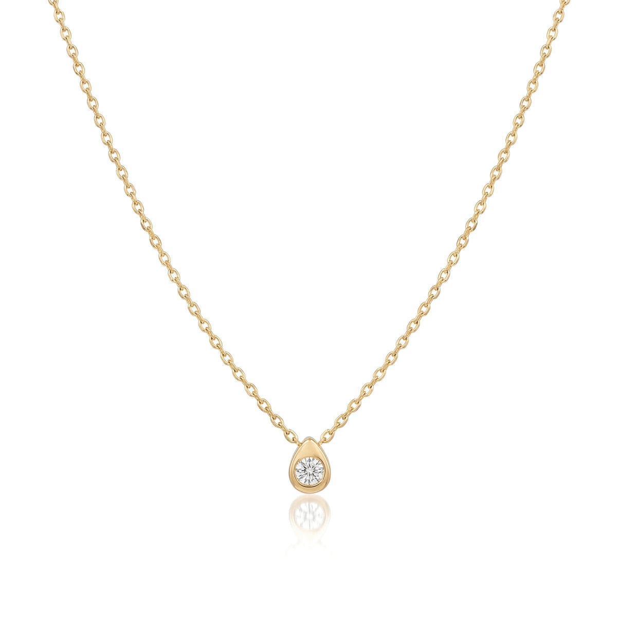 14K yellow gold pear drop necklace, small teardrop pendant with a bezel-set clear stone, on white