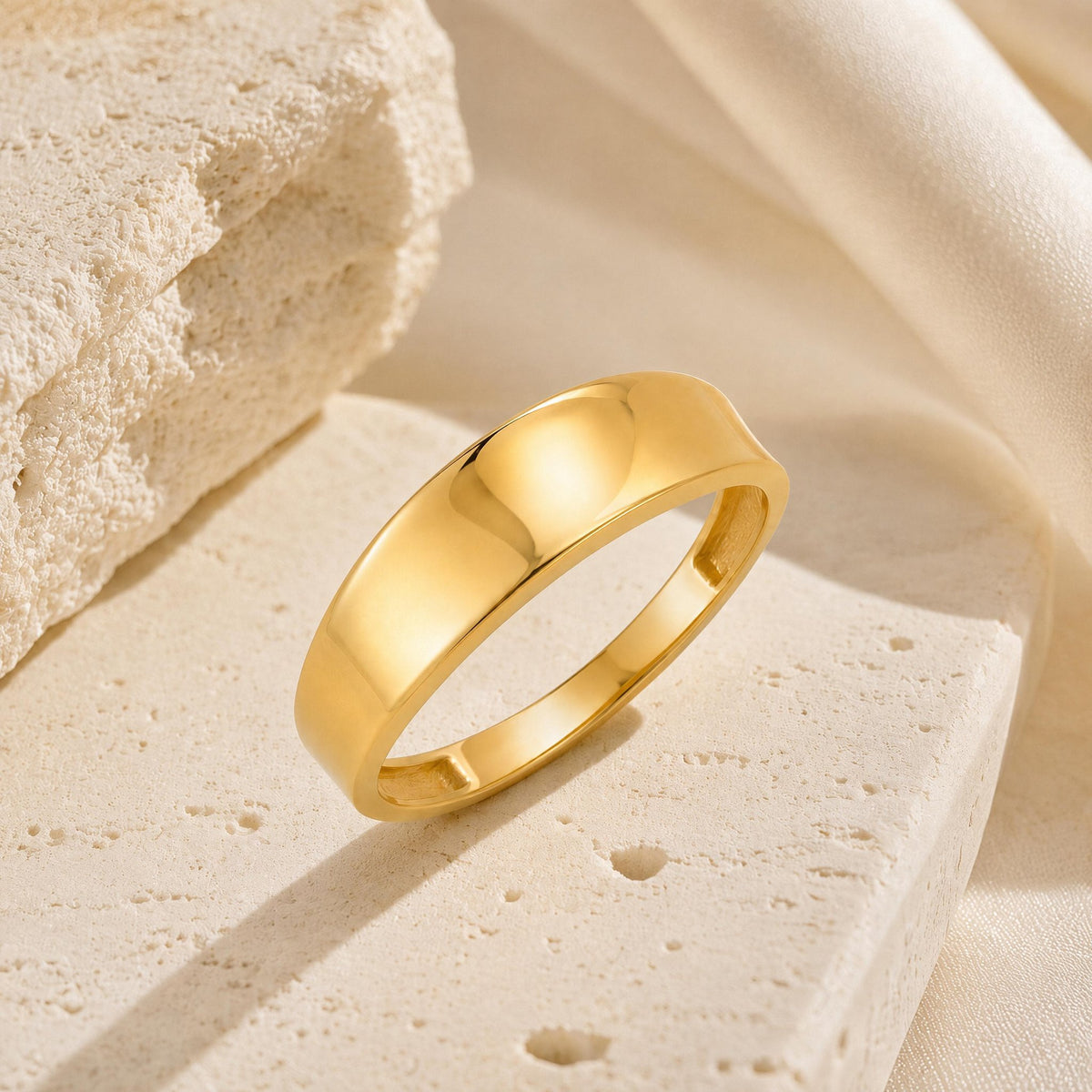 14K gold plain band ring styled on a neutral backdrop
