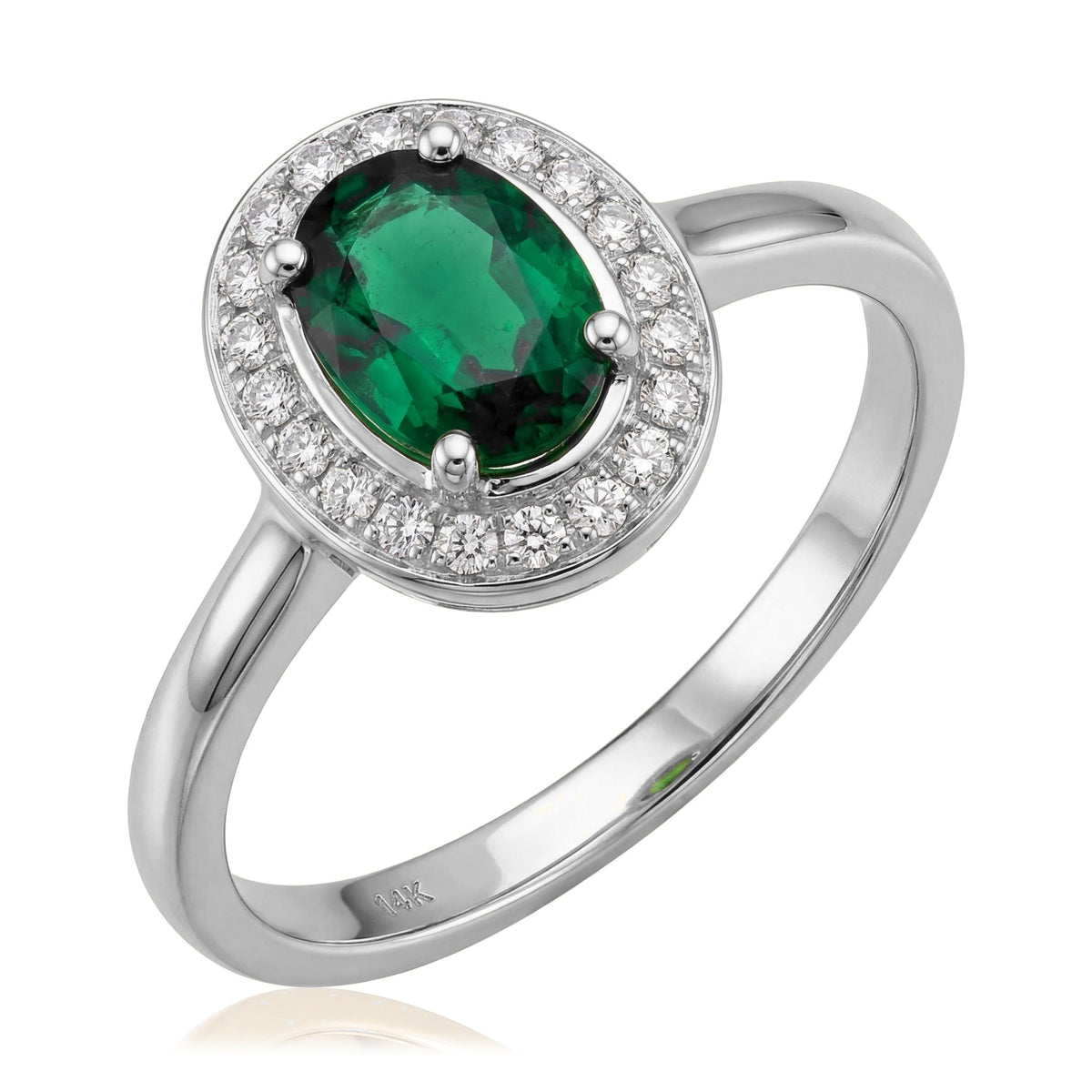 14K white gold simulated emerald ring, oval green stone in a halo of small clear stones, angled on white
