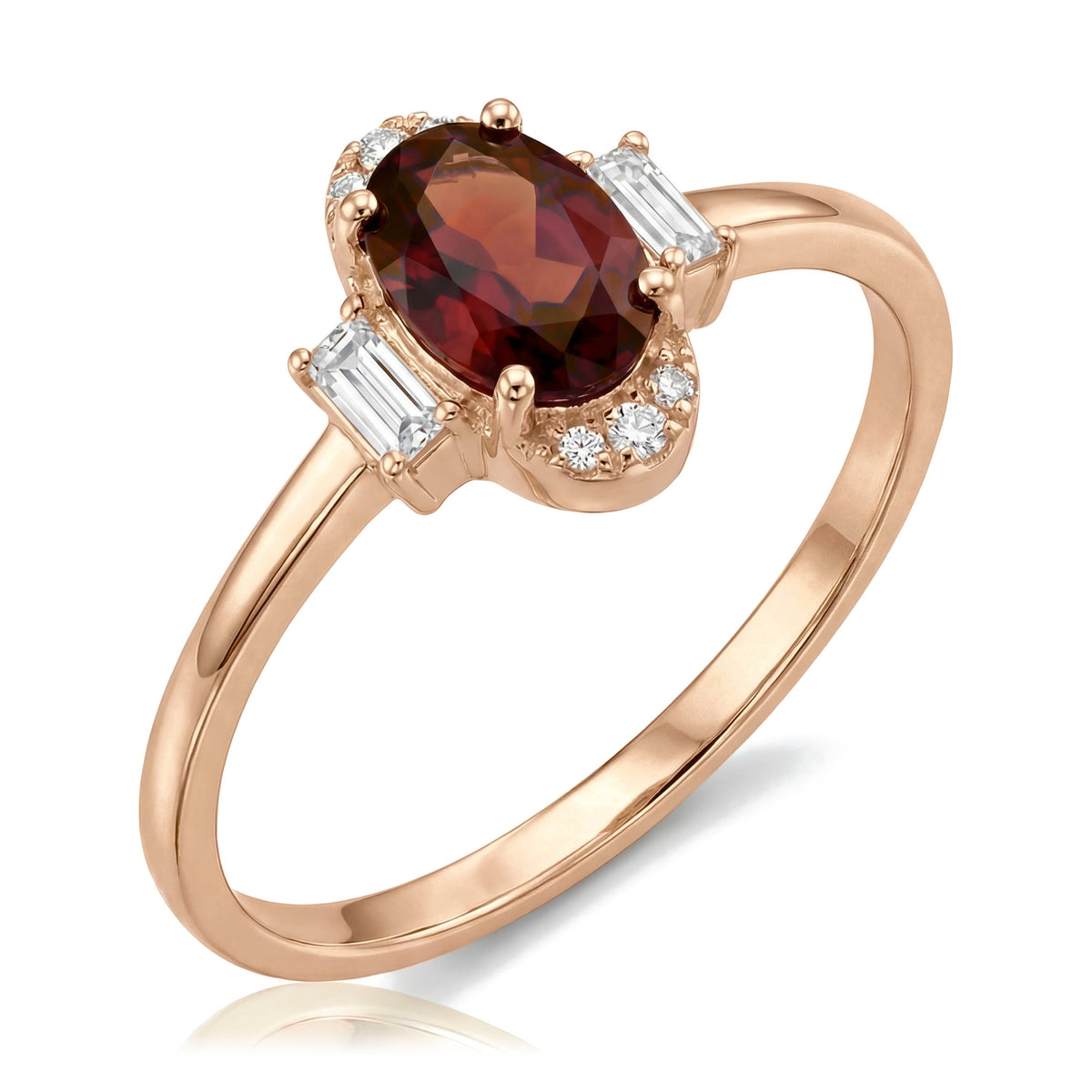 14K rose gold simulated ruby ring, oval dark red stone flanked by baguette accents, angled view on white