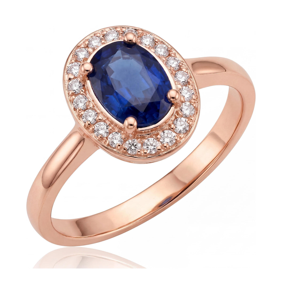 14K rose gold simulated sapphire ring, oval blue stone in a halo of small clear stones, angled on white