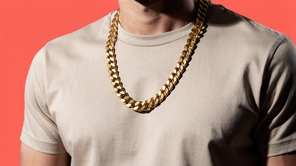 Men's gold curb chain necklace worn over a t-shirt showing necklace length
