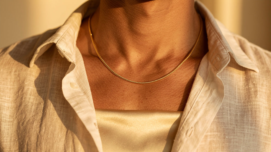 Man wearing a gold chain at the average necklace length for a man