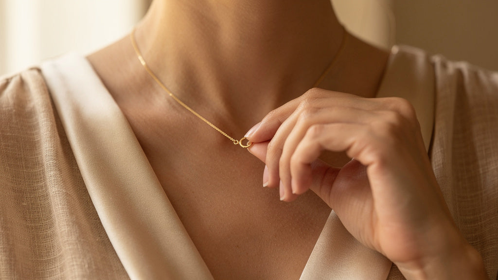 Woman adjusting a 14K gold necklace clasp, showing everyday wear that raises the does 14K gold tarnish question