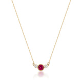 14K gold necklace with central red Simulated Ruby and two small clear stones on white background