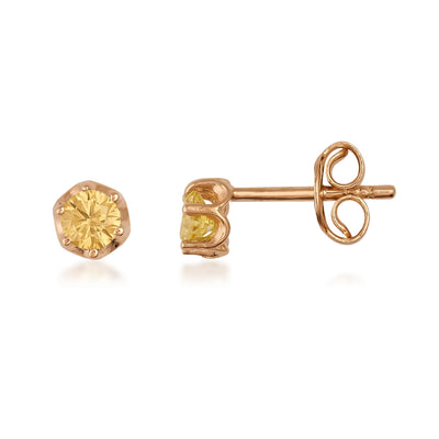Yellow gemstone gold stud earrings with hexagonal setting on white background