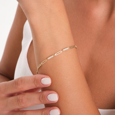 Gold bracelet on a wrist with a blurred background