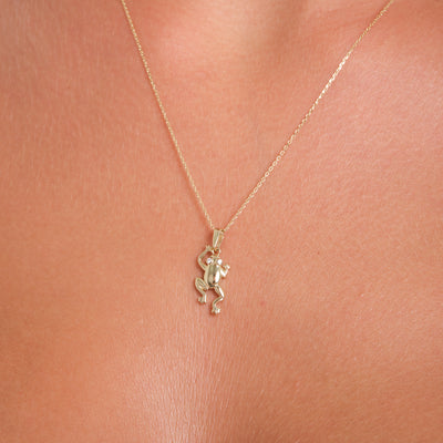 Gold necklace with a small pendant on a skin background