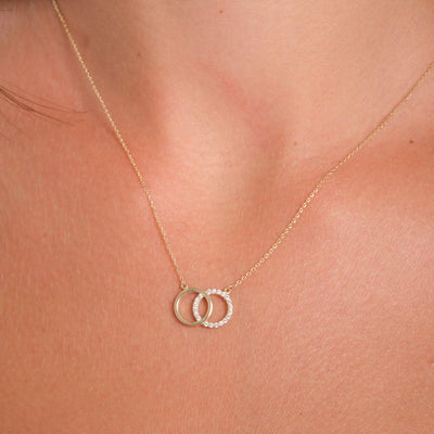 Gold necklace with interlocking rings on a person's neck