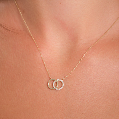 Gold necklace with interlocking rings on a person's neck