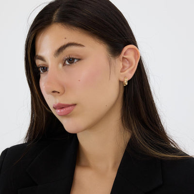 14K gold bamboo hoop earring with round cubic zirconia worn on the ear, model in black blazer, three-quarter view