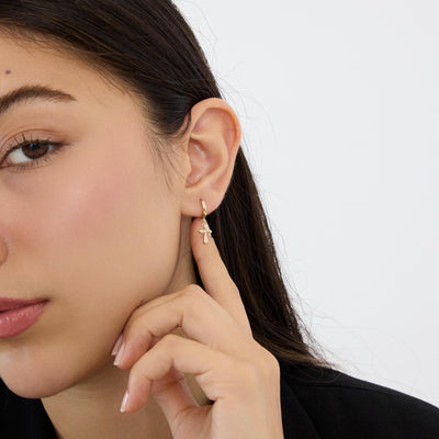 14K gold cross hoop earrings styled on a neutral backdrop, fourth angle