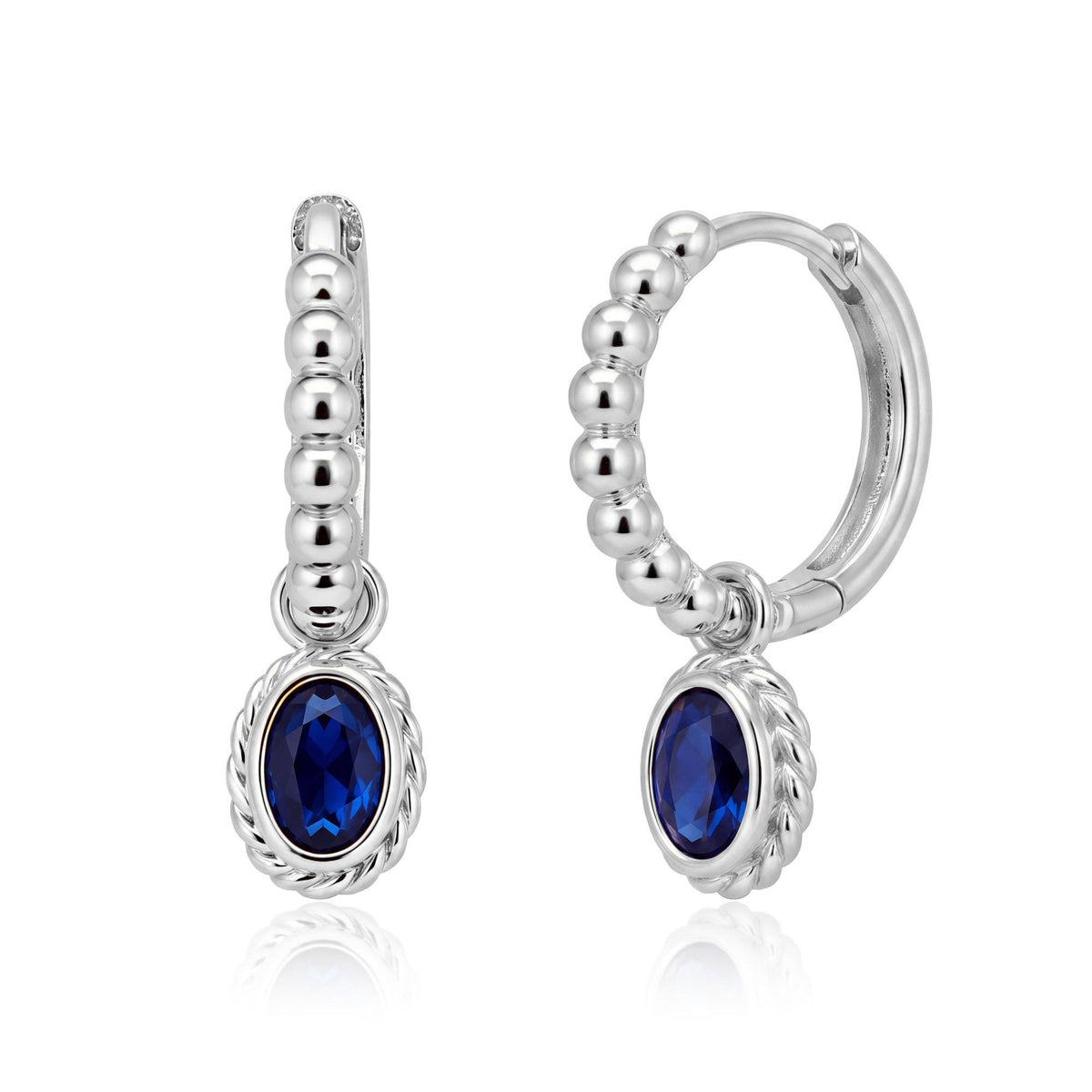Pair of 14K white gold beaded huggie earrings with oval blue stone drops and twisted rope bezel