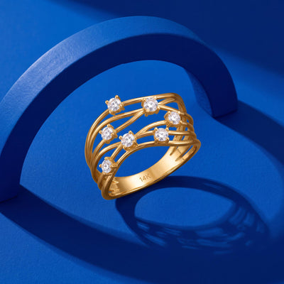 14K yellow gold CZ statement ring on a cobalt blue arch set, angled to show the stamped inner band