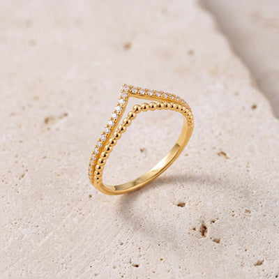 14K gold double chevron ring with cubic zirconia pave on stone surface