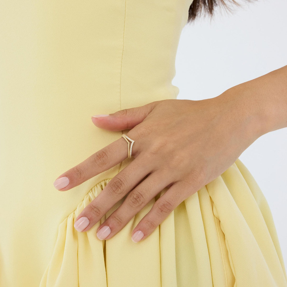 14K gold double chevron ring on hand resting against hip, side view