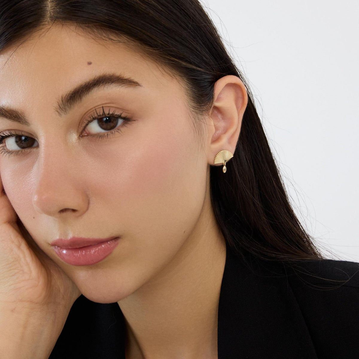14K gold fan drop stud earring with marquise cubic zirconia worn on ear, model with face turned toward camera
