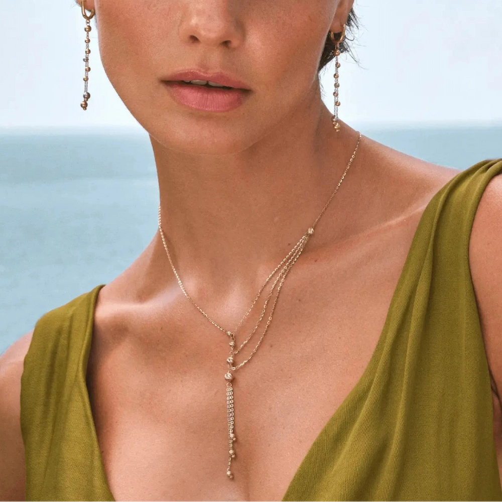 Elegant gold jewelry set featuring a delicate chain necklace and matching  earrings.
