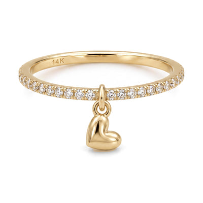 14K yellow gold heart charm ring, clear stone band with a dangling puffed heart, front view on white