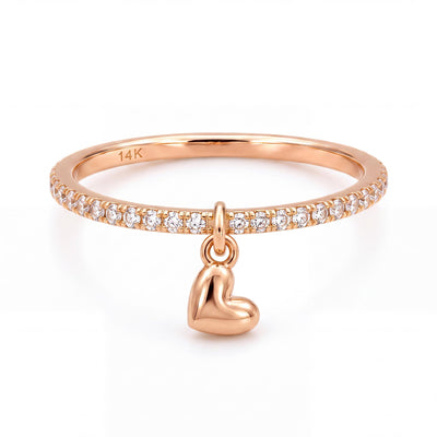 14K rose gold heart charm ring, clear stone band with a dangling puffed heart, front view on white
