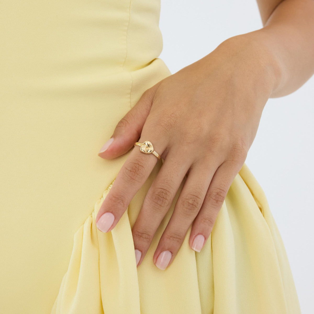 14K gold heart dome ring on hand resting against hip in yellow dress