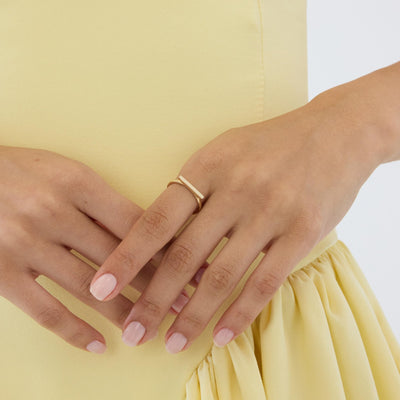 14K gold horizontal bar ring worn on finger resting on opposite hand