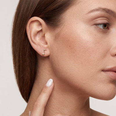 14K gold music note stud earrings, styled view
