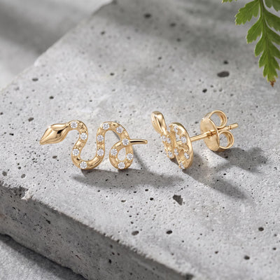 14K gold snake stud earrings styled on a neutral backdrop