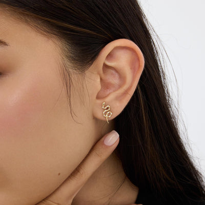 14K gold snake stud earrings styled on a neutral backdrop, second angle