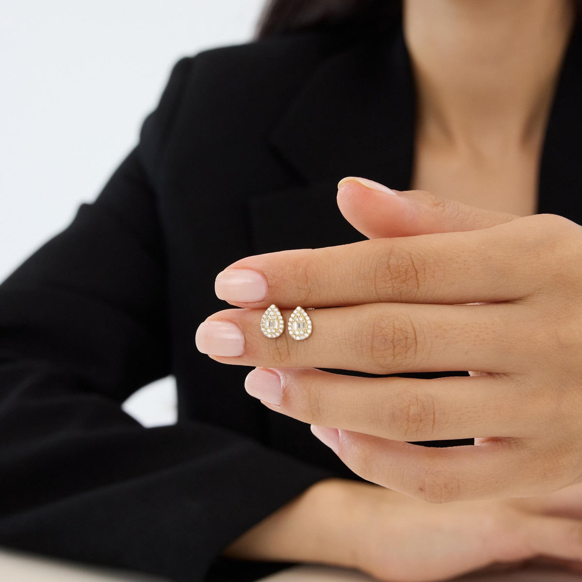 14K gold teardrop stud earrings styled on a neutral backdrop, second angle
