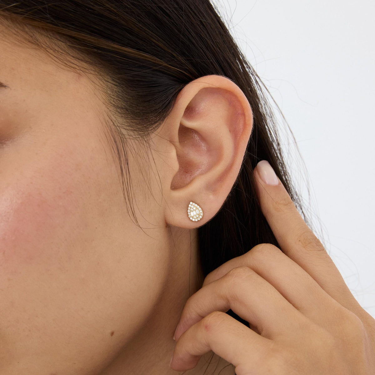 14K gold teardrop stud earrings styled on a neutral backdrop, fourth angle